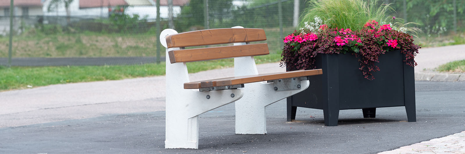 Un banc en béton blanc avec des sièges et un dossier en bois.